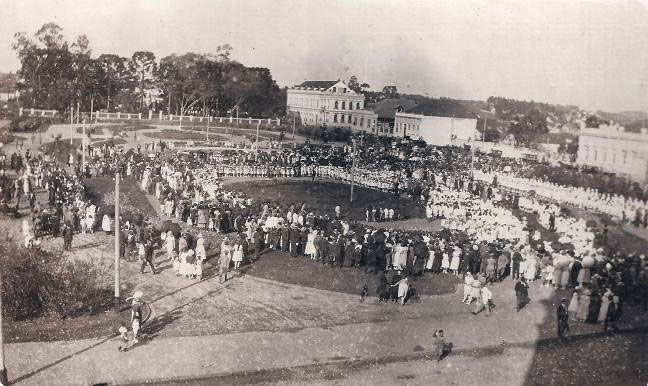 Inauguração da herma do padre Ildefonso na Praça Santos Andrade, em setembro de 1922. Evento integrante das comemorações do Centenário da Independência do Brasil. Ao fundo, a antiga sede do Colégio Santa Maria.