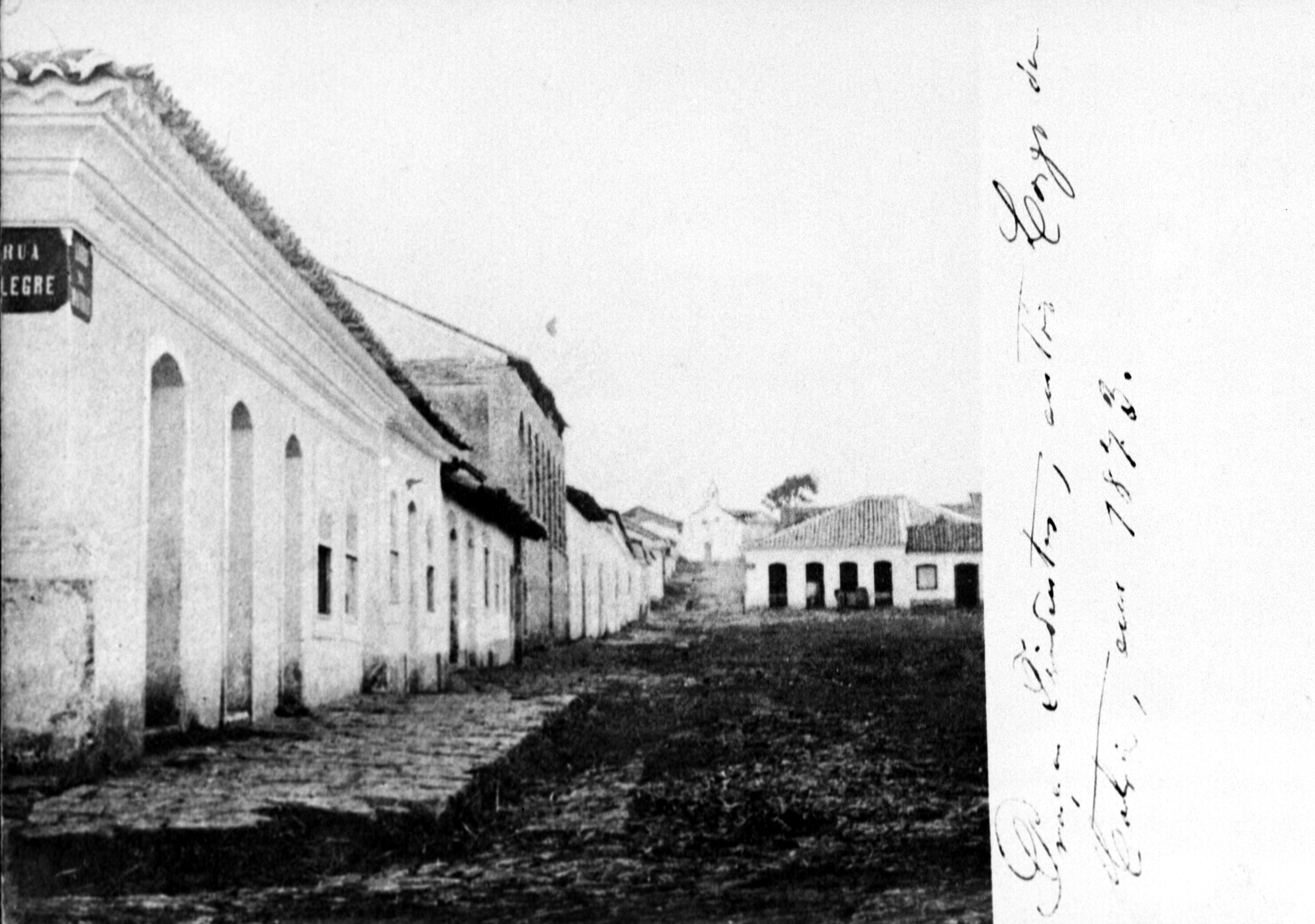 Largo da Matriz, em 1873. Ao fundo, a antiga Igreja do Rosário. Destaca-se a ausência de delimitação passeio/via/praça, assim como da pavimentação. Predomina o casario com características coloniais.