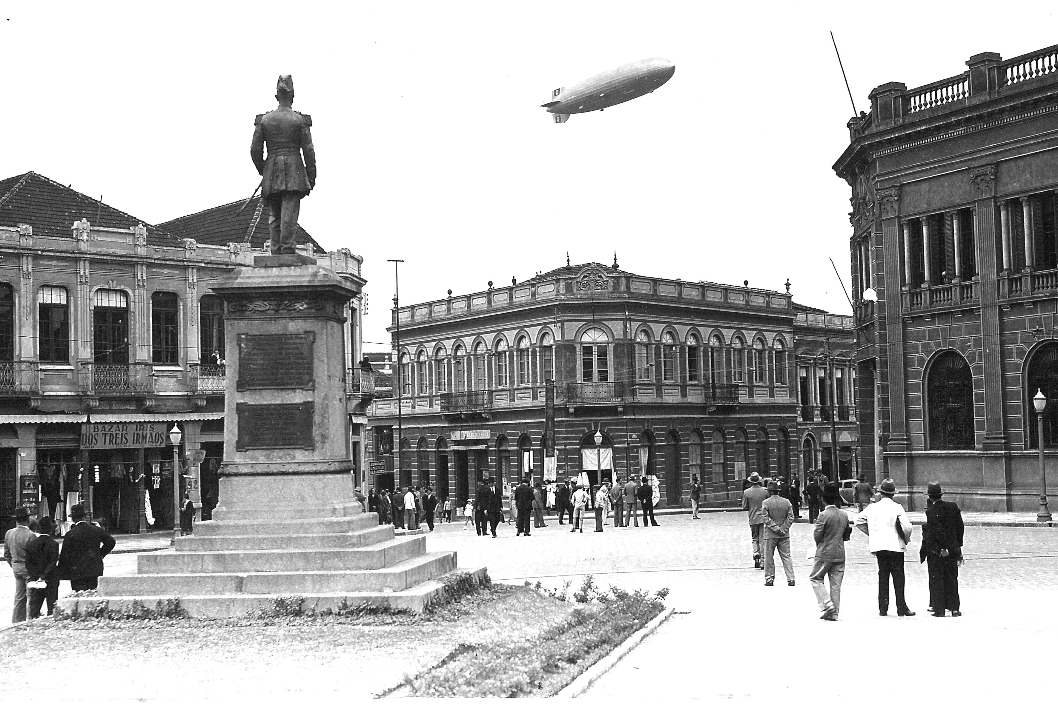 Passagem do Zepelin pela Praça Tiradentes, em 1932. Em primeiro plano, a estátua do Marechal Floriano Peixoto. À direita, encontra-se a antiga Agência do Banco do Brasil, projetada pelo engenheiro Eduardo Fernando Chaves e demolida na década de 1950.